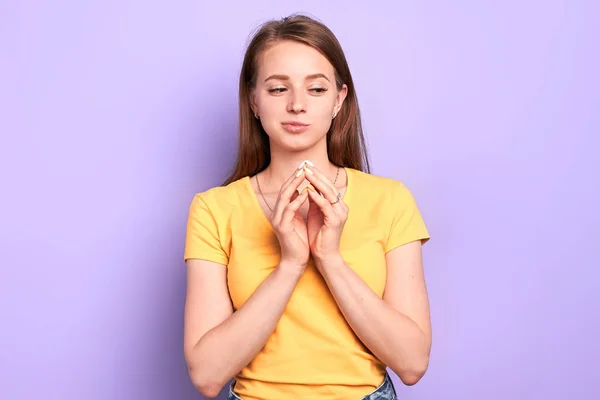 Young pretty woman with thoughtful look, keeps hands in praying gesture — Stock Photo, Image