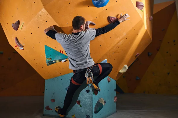 Back view of young strong sportsman without forearm rock climbing — Stock Photo, Image