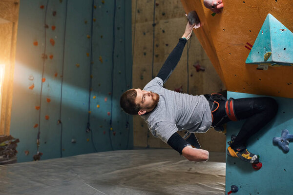 Powerful handsome boulderer without forearm training at climbing gym