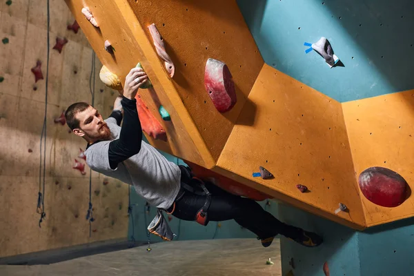 Muscular physically challenged climber moving up on steep rock