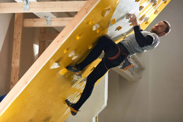 Athletischer männlicher Boulderer mit körperlicher Behinderung klettert an steiler Felswand — Stockfoto