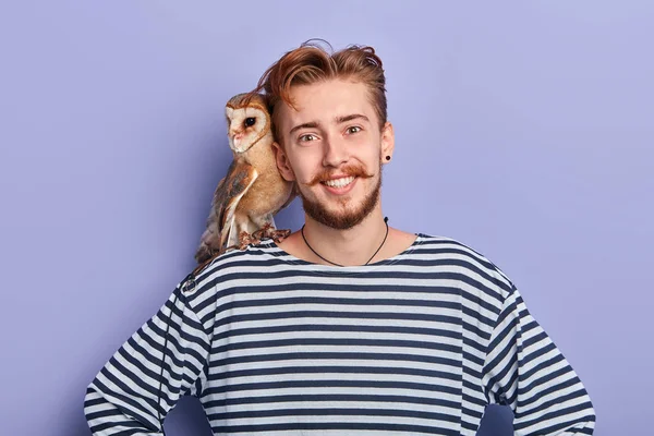 Smiling positive guy with hands on the hips offers to take a photo with his bird — Stock Photo, Image