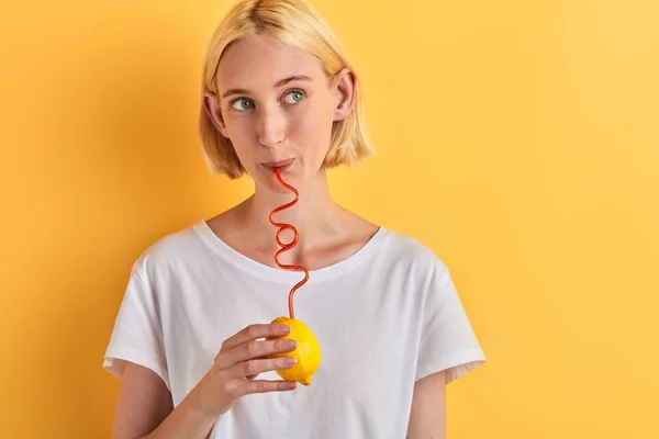 Funny woman drinking lemon juice with straw — Stock Photo, Image