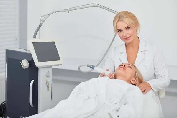 Cosmetologist massaging client.s facial skin — Stock Photo, Image