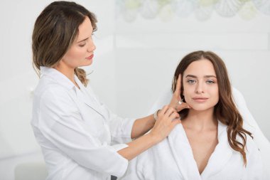 genç yetenekli doktor elinde şırınga ve kadın cilt geliştirmek için gidiyor