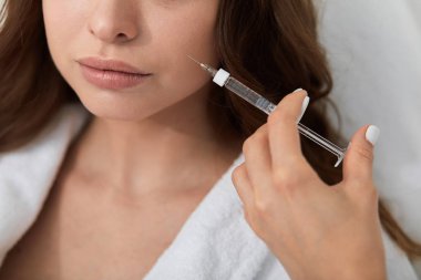 bir şırınga tutan doktor, o kadın hasta öldürmek için gidiyor