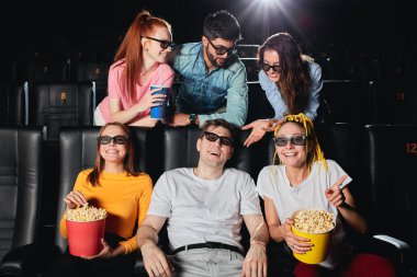 Sinemada oturan ve film izleyen çok ırklı neşeli seyirci