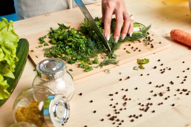 Tanınmayan kadınlar yeşil sos için maydanoz ve taze soğan kesme elleri