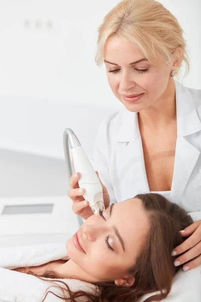 Relazed beautiful brunette woman having facial treatment in beauty salon — Stock Photo, Image