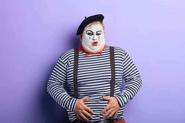 Funny mime with painted face touching his belly — Stock Photo, Image