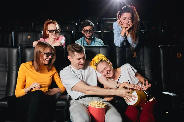 Aantrekkelijk jong stel plezier met popcorn terwijl andere mensen ze bekijken — Stockfoto