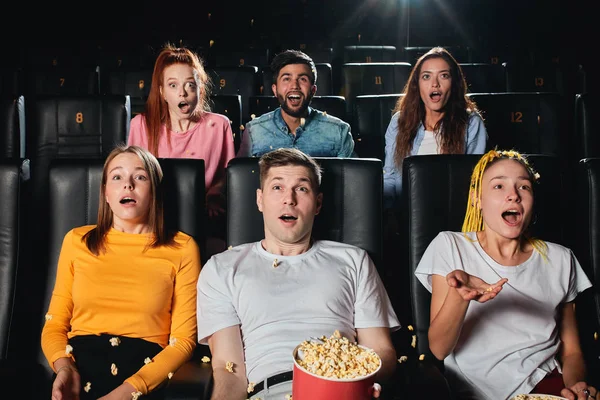 Opgewonden emotionele gemengde race vrienden met popcorn kijken naar film in de bioscoop — Stockfoto