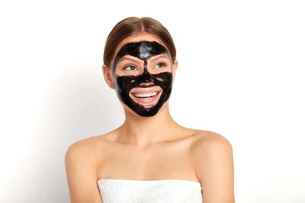 Šťastná atraktivní mladá žena používající černou obličejmasku — Stock fotografie