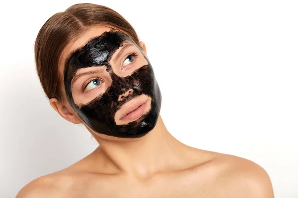 Ernste Frau mit reinigender schwarzer Maske im Gesicht, die nach oben schaut — Stockfoto
