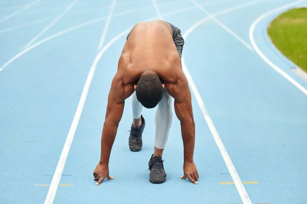 Löpare med stark muskulös kropps träning på arenan — Stockfoto