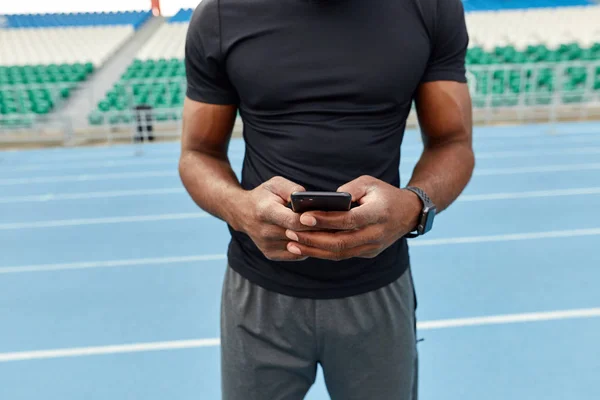 muscular well-built man typing message, making a phone call