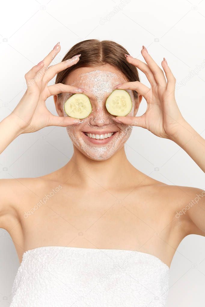 positive beautiful girl making glasses from slices of cucumber