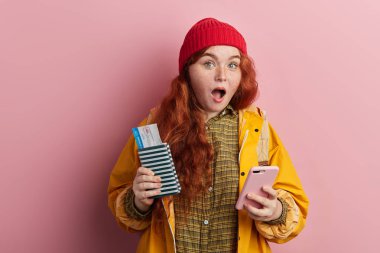 Geniş açık ağız ile gezgin turist onun akıllı telefon tutarak