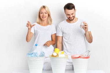 farklı çöp kutuları kullanarak beyaz t-shirt neşeli gençler.