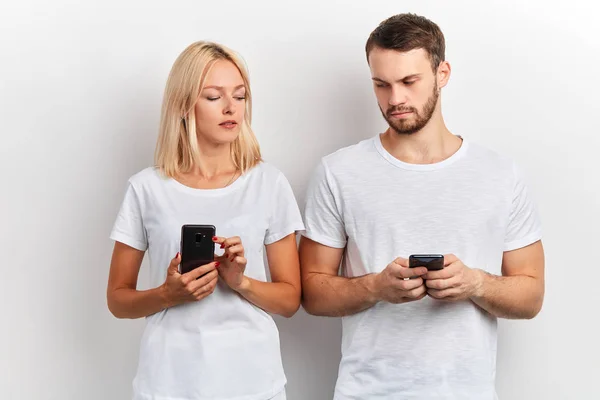 Dos personas atractivas comparando sus teléfonos inteligentes — Foto de Stock