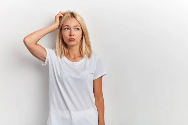 Retrato de cerca de la joven mujer desconcertada rascándose la cabeza —  Fotos de Stock