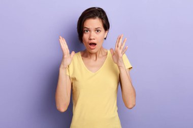 Şaşıran genç kadın bağırıyor, şok uyguluyor, avuçlarını yüzüne yakın tutuyor