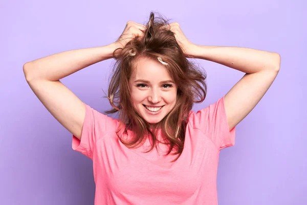 Fille gaie souriant ludique, gâcher les cheveux avec les mains après bataille d'oreiller — Photo