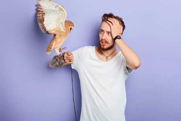 Man is being afraid of angry agressive bird — Stock Photo, Image