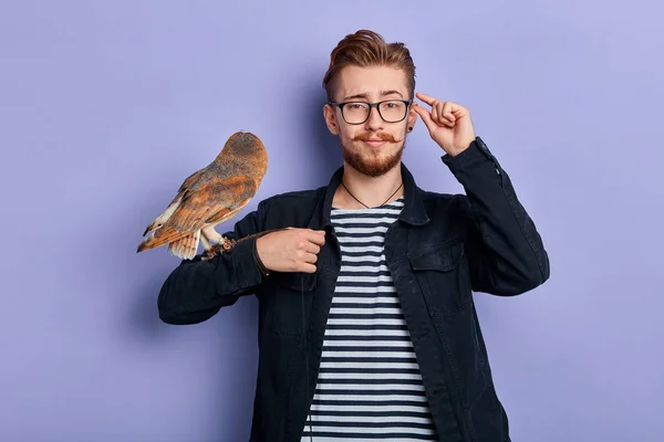 Young funny man with owl in his arm pretending Harry Potter — Stock Photo, Image