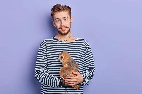 Kind friendly guy holding a beautiful owl in hands — Stock Photo, Image