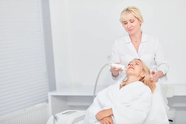 Terapeuta trabajador levantando, limpiando la piel facial del paciente. primer plano foto — Foto de Stock