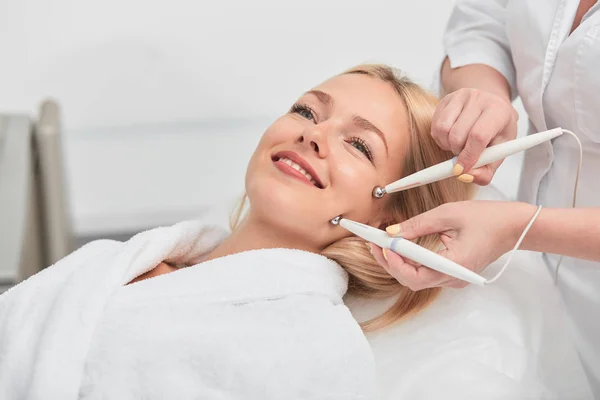 Alegre sonriente impresionante rubia mujer teniendo microcurrent medicina tratamiento . — Foto de Stock