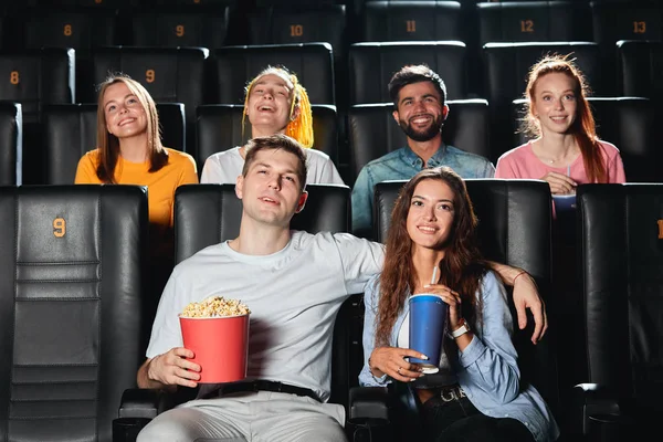 Pareja feliz comiendo palomitas de maíz, bebiendo cola mientras ve la película — Foto de Stock