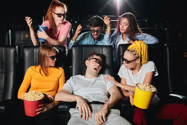 Jonge gefrustreerde mensen ruzie een man die slaapt in de bioscoop — Stockfoto