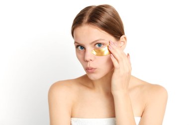 gözlerinin altında maske uygulayan genç hoş güzel kız