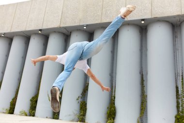 Sportif atlet uçan ve sokakta yerden flipping.