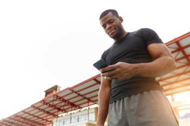 yakışıklı Afrikalı çalıştırıcı, antrenör stadyumda tek başına duruyor.