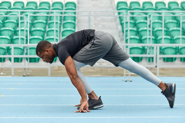 Young muscular athlete preparing to sprint — Stock Photo, Image