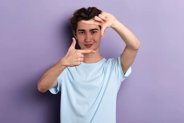 Handsome guy making a frame with fingers looking at the camera — Stock Photo, Image