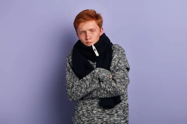 Slabý mladý muž, který nosí na sobě módní svetr a šátek stojící s zkříženou náručí — Stock fotografie