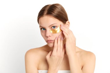 kahverengi saçlı kadın göz altında altın kollajen kristal anti-kırışıklık yapıştırma