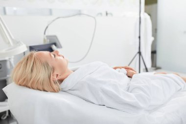 adil saçlı kadın bir tıbbi sandalyede yatarken sakin kalan