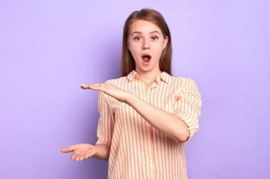 Bitirmesi gereken belgelerle klasör boyutunu gösteren genç kadın ofis çalışanı