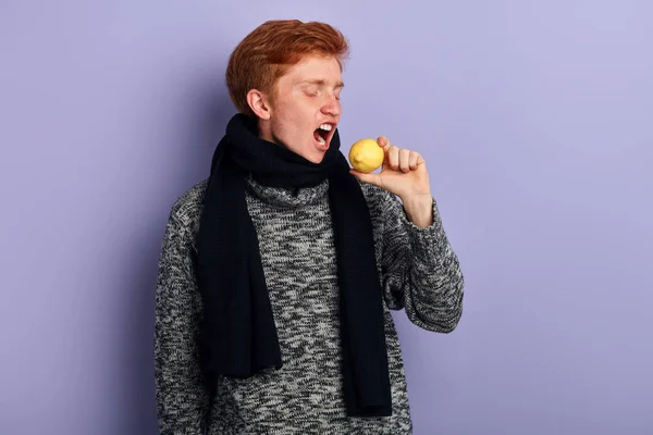 Young man eating a lemon , he wants to recover from illness — Stock Photo, Image