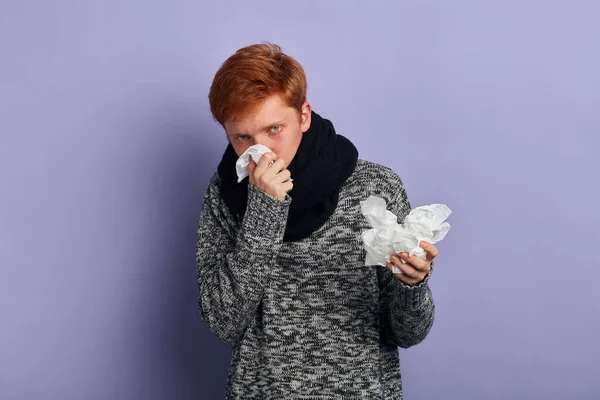 Hombre sosteniendo una pila de servilletas, sonándose la nariz. estudiante tiene mirada enferma —  Fotos de Stock