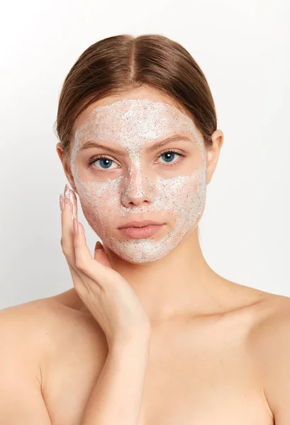 Ehrfürchtige junge Frau berührt ihr Gesicht, während sie Zeit im Wellness-Salon verbringt — Stockfoto