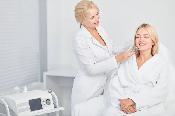 Terapeuta massaggiare le donne faccia sul posto di lavoro — Foto Stock