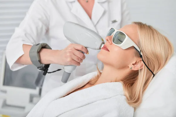 Avslappnad ung blond klient emot Hårborttagning laser epilering — Stockfoto