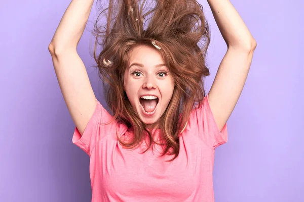 Игривая молодая женщина прыгает высоко, крича громко, грязные волосы вверх — стоковое фото