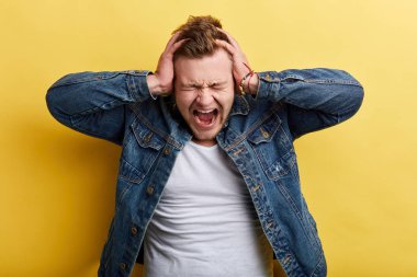 Kızgın deli öfkeli sinirli adam elleriyle başını tutarak bağırarak
